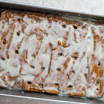 Condensed milk poured over the top of a baked pumpkin cake,