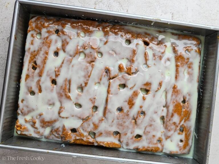 Condensed milk poured over the top of a baked pumpkin cake,
