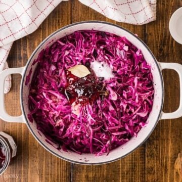 Jam, salt, cloves, and bay leaf added to the pot of red cabbage.