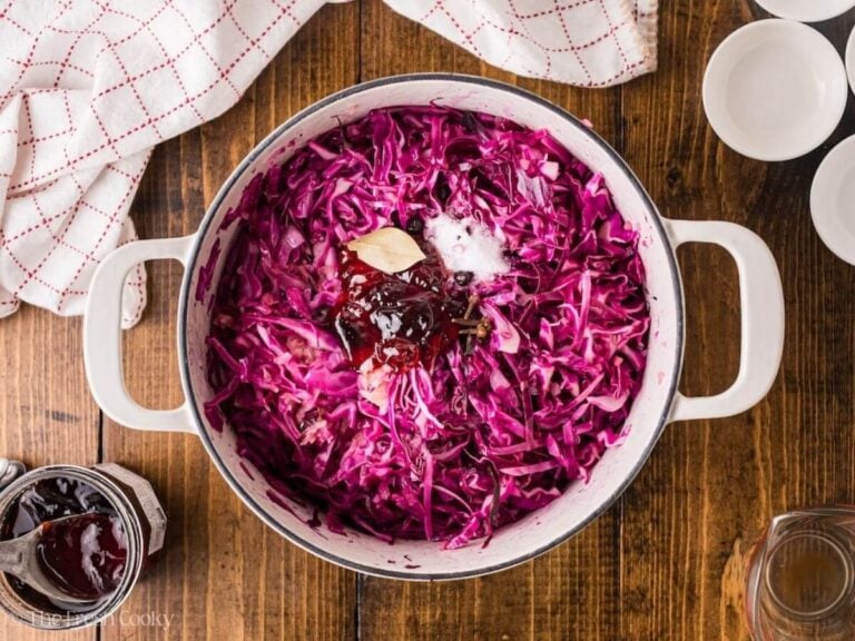 Jam, salt, cloves, and bay leaf added to the pot of red cabbage.