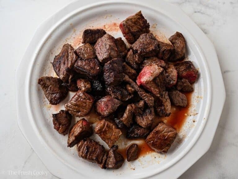 Seared beef cubes on a plate.