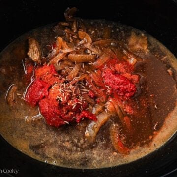 Broth, tomato paste, and spices added to the slow cooker.