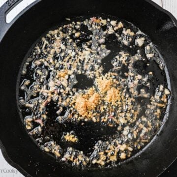 Sautéing shallots and garlic in butter in pan.