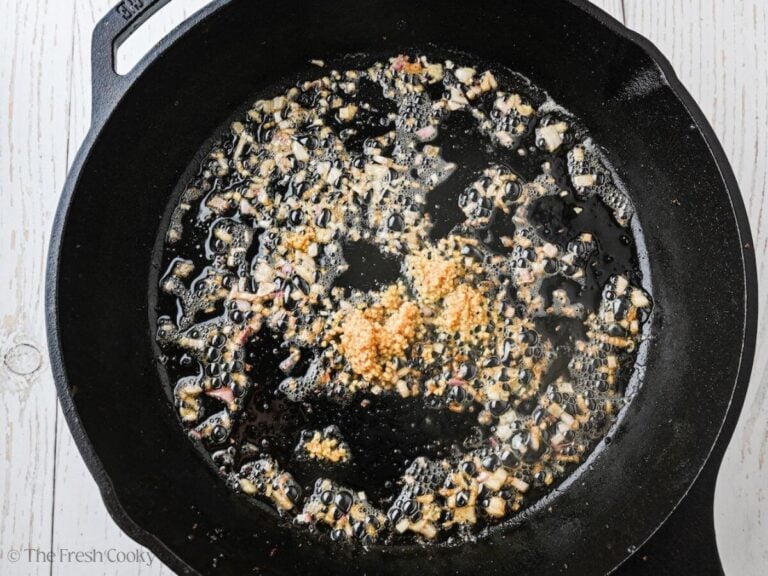 Sautéing shallots and garlic in butter in pan.