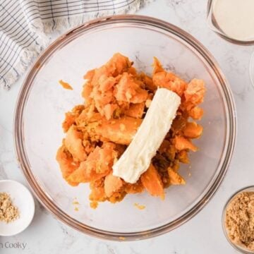 Sweet potatoes and a stick of butter in a mixing bowl.