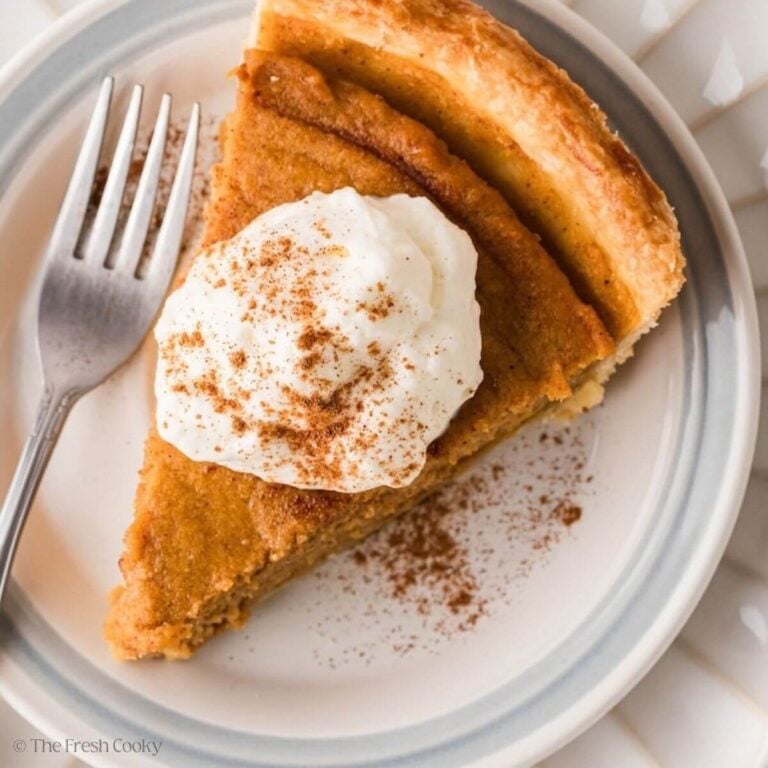 Overhead shot of a slice of sweet potato pie with whipped cream on top.