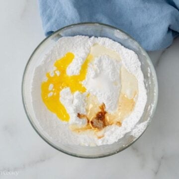 Powdered sugar with milk, melted butter, vanilla, in a small bowl.