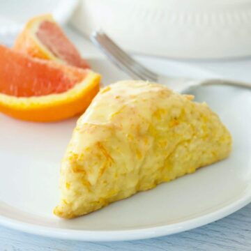 Orange Scone copycat Panera recipe on plate with fork and slice of orange.